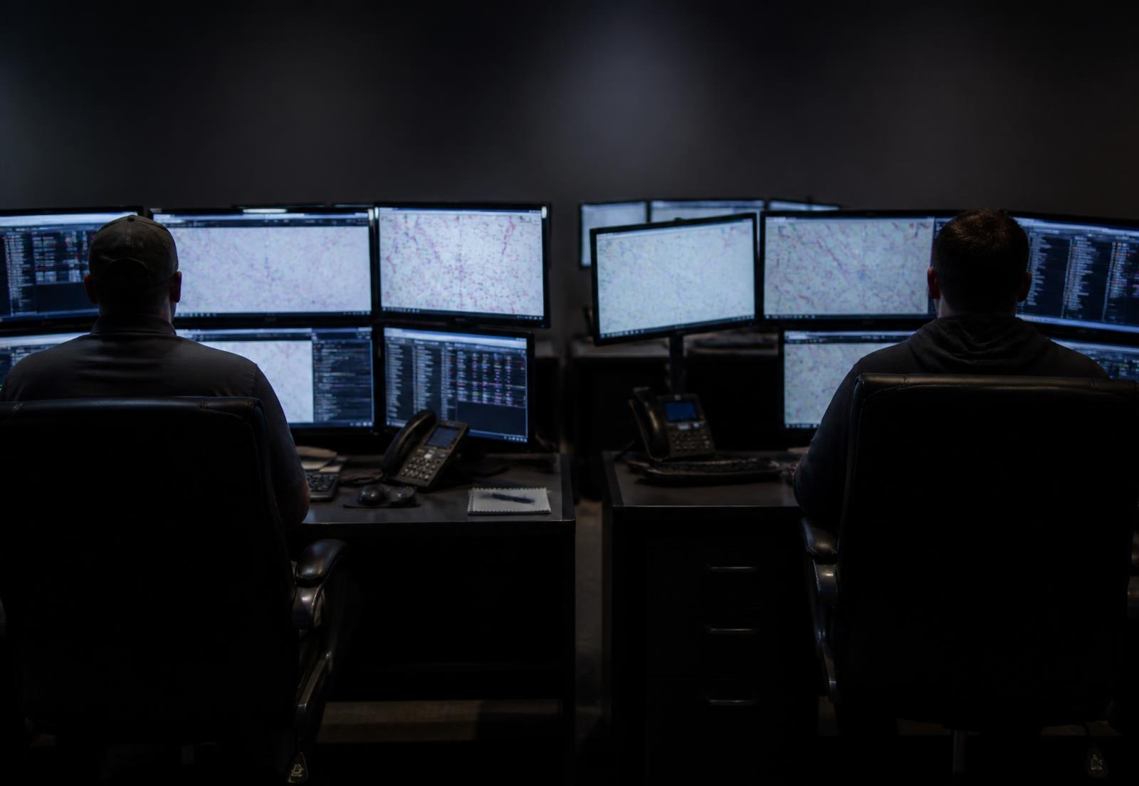 Dispatch team monitoring routes and loads on multiple screens at night